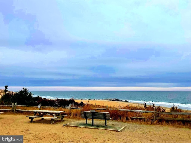 surrounding community featuring a water view and a beach view