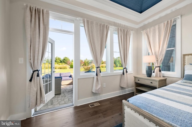 bedroom featuring dark wood-type flooring, ornamental molding, and access to exterior