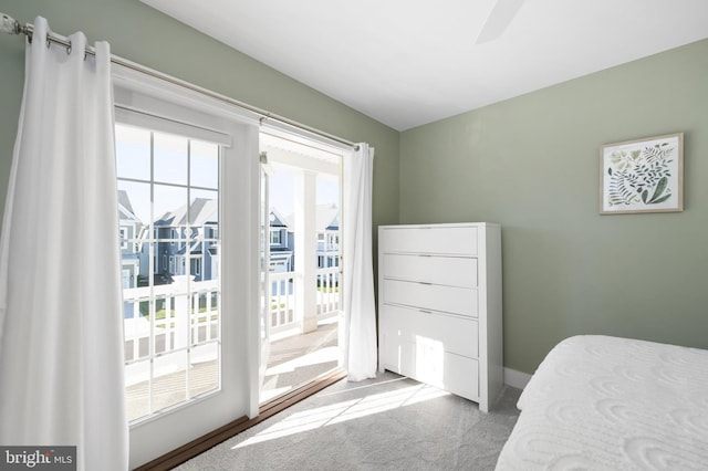 bedroom featuring access to exterior, light colored carpet, and ceiling fan