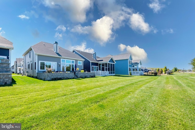 rear view of property with a lawn