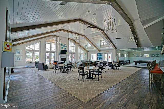 dining area with beam ceiling, hardwood / wood-style floors, and high vaulted ceiling