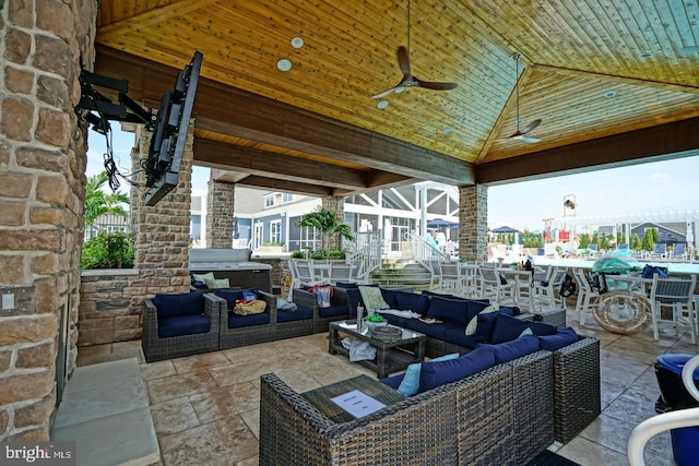 view of patio / terrace with a gazebo, ceiling fan, an outdoor hangout area, and glass enclosure