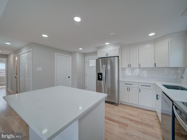 kitchen with sink, stainless steel appliances, white cabinets, and a kitchen island