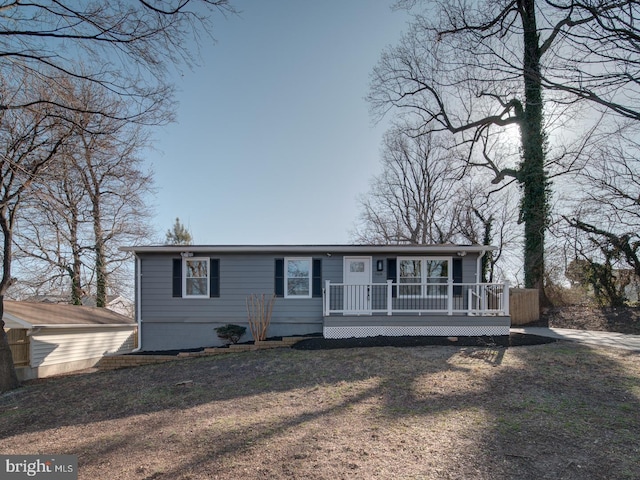 view of front of property featuring a deck and a front lawn