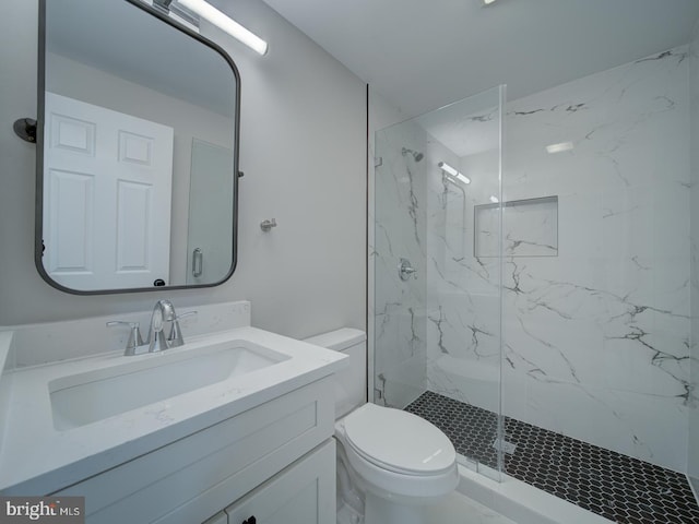 bathroom featuring vanity, toilet, and a shower with door