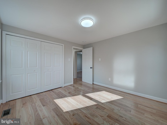 unfurnished bedroom with a closet and light hardwood / wood-style flooring