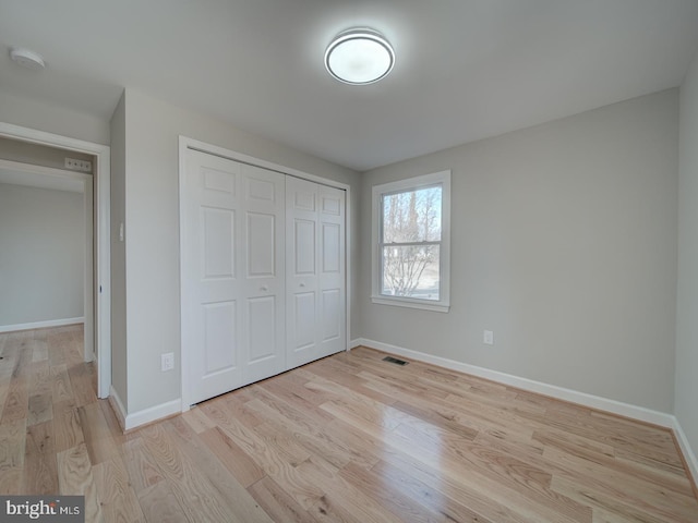 unfurnished bedroom featuring light hardwood / wood-style floors and a closet