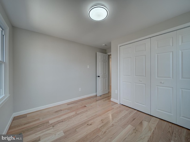 unfurnished bedroom with a closet and light hardwood / wood-style flooring