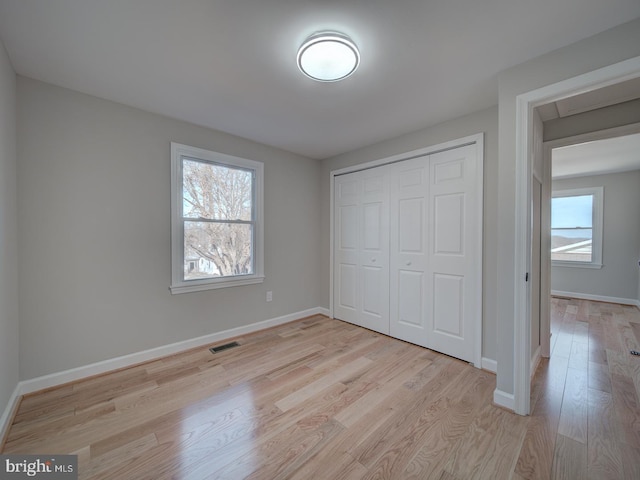 unfurnished bedroom with a closet and light hardwood / wood-style flooring