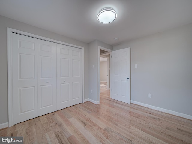 unfurnished bedroom featuring light hardwood / wood-style floors and a closet