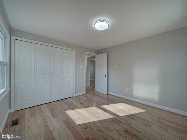 unfurnished bedroom featuring light hardwood / wood-style flooring and a closet