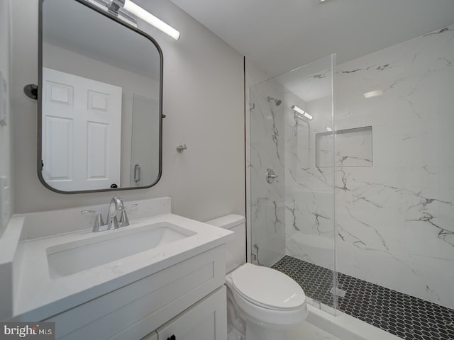 bathroom featuring vanity, a shower with shower door, and toilet