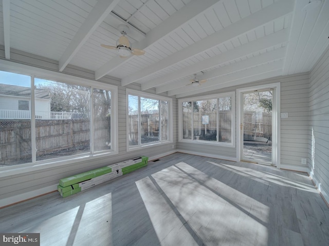 unfurnished sunroom with ceiling fan, plenty of natural light, and beam ceiling