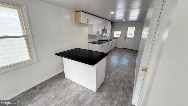 kitchen featuring sink, wood-type flooring, and white cabinets