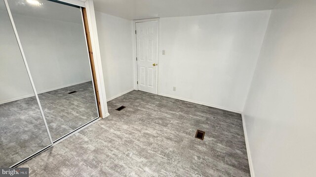 unfurnished bedroom with hardwood / wood-style flooring and a closet