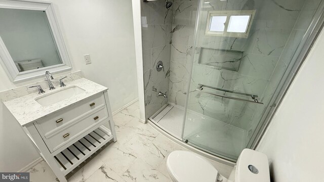 bathroom with vanity, toilet, and a shower with door