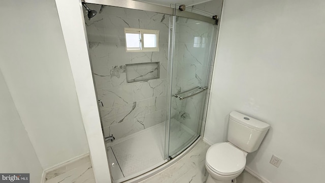 bathroom with a shower with shower door and toilet