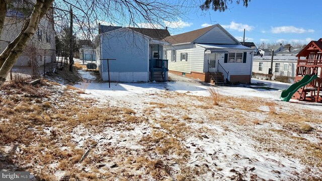 view of snowy exterior featuring a playground