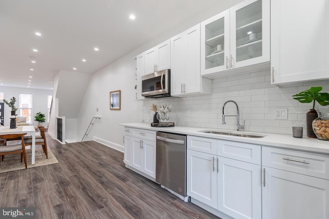 kitchen featuring sink, appliances with stainless steel finishes, dark hardwood / wood-style flooring, white cabinets, and backsplash