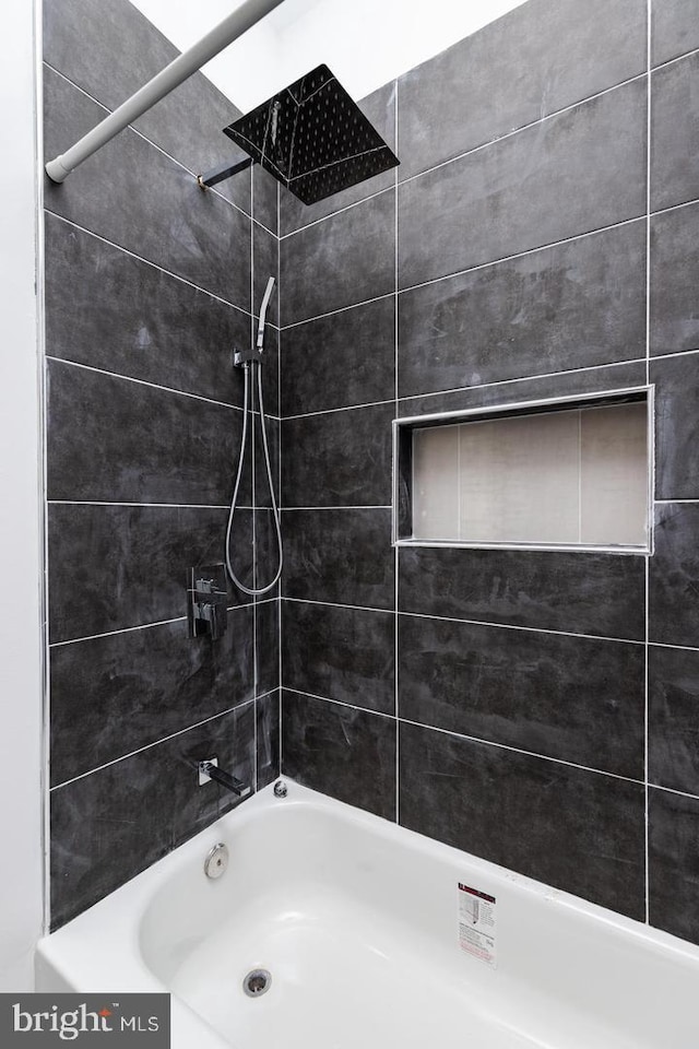 bathroom featuring tiled shower / bath