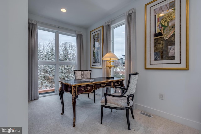 home office with a wealth of natural light and light colored carpet