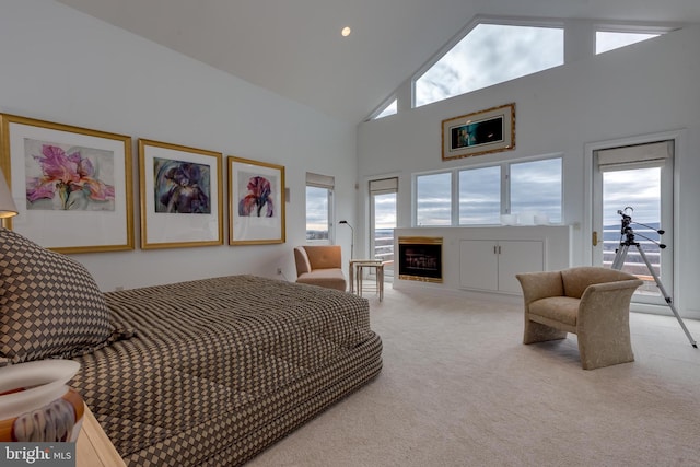 bedroom with high vaulted ceiling, access to outside, light colored carpet, and a fireplace