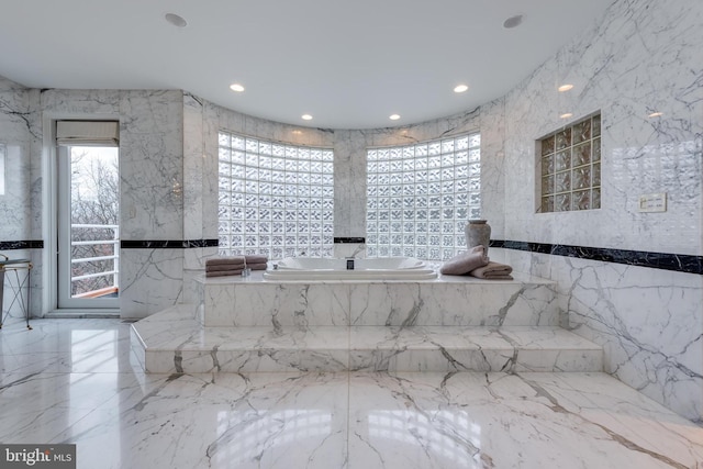 bathroom with tile walls and a bathtub