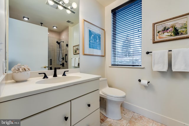 bathroom with vanity, a shower with shower door, and toilet