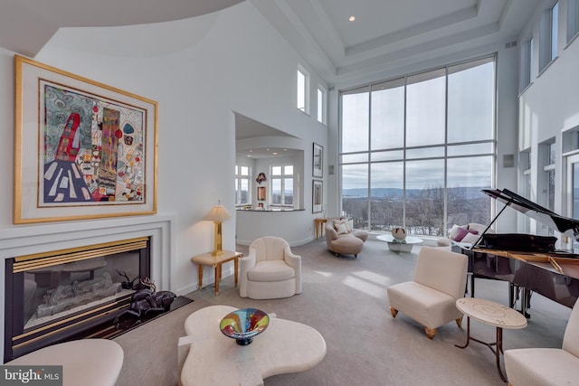 living room with a high ceiling, a mountain view, and carpet floors