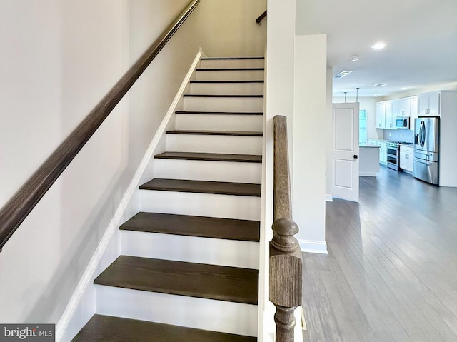 staircase with hardwood / wood-style floors