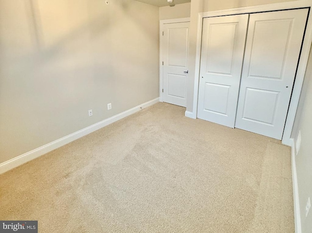 unfurnished bedroom with a closet and light carpet