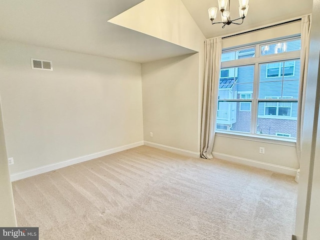 carpeted spare room featuring vaulted ceiling and a notable chandelier