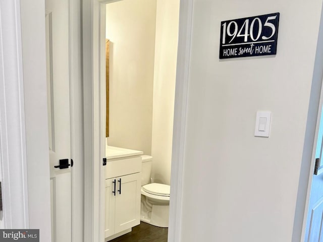 bathroom featuring vanity, wood-type flooring, and toilet