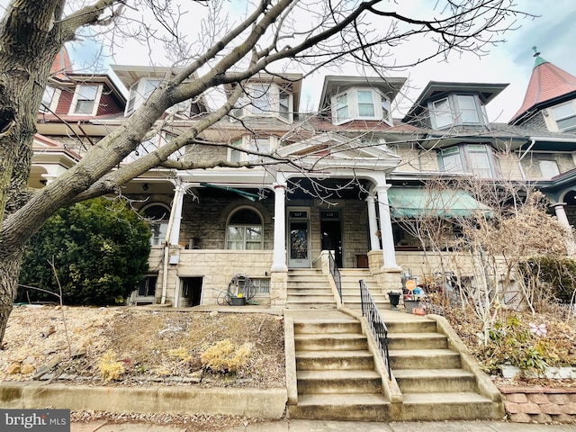 view of front of home with stone siding and a porch