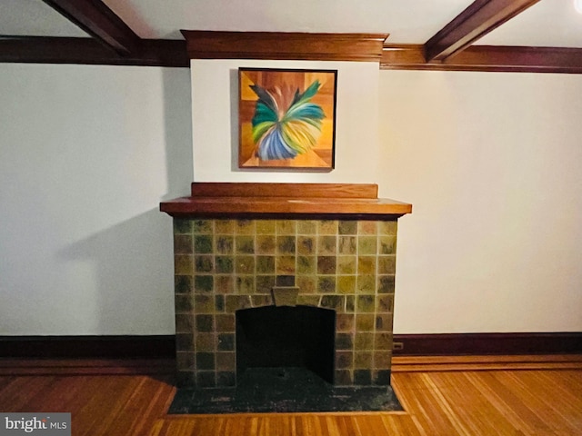 room details featuring a fireplace with flush hearth, wood finished floors, beam ceiling, and baseboards