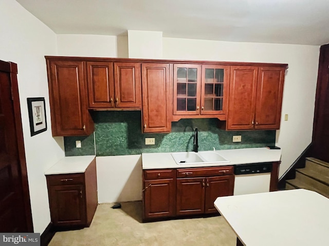 kitchen featuring light countertops, white dishwasher, a sink, and glass insert cabinets