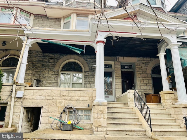 exterior space featuring stone siding and a porch