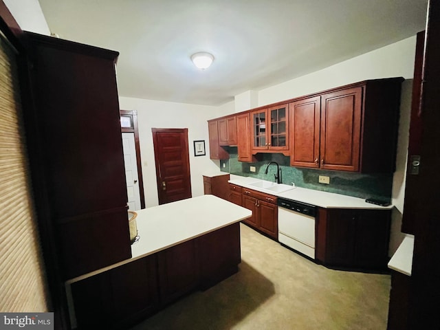 kitchen with white dishwasher, light colored carpet, a sink, light countertops, and glass insert cabinets