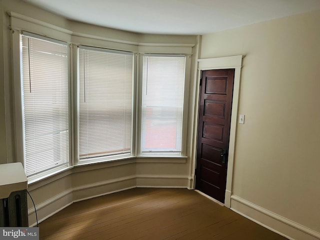 interior space with baseboards and dark wood-style flooring