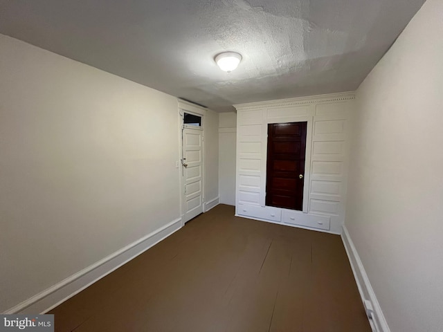 empty room with a textured ceiling and baseboards