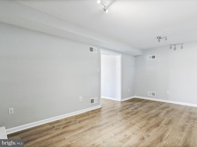 spare room with track lighting and light wood-type flooring