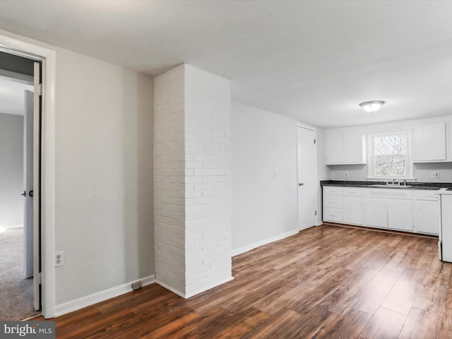 kitchen featuring white cabinetry, dark wood-type flooring, stove, and sink