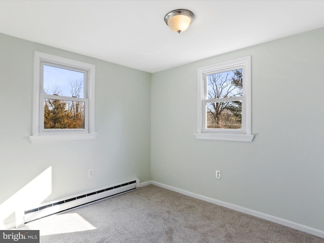 carpeted spare room featuring baseboard heating