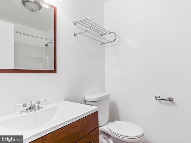 bathroom featuring vanity, toilet, and a shower