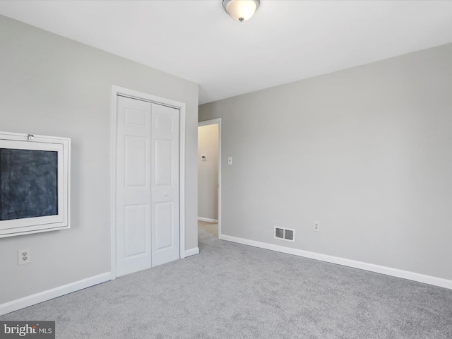 unfurnished bedroom with a closet and carpet flooring