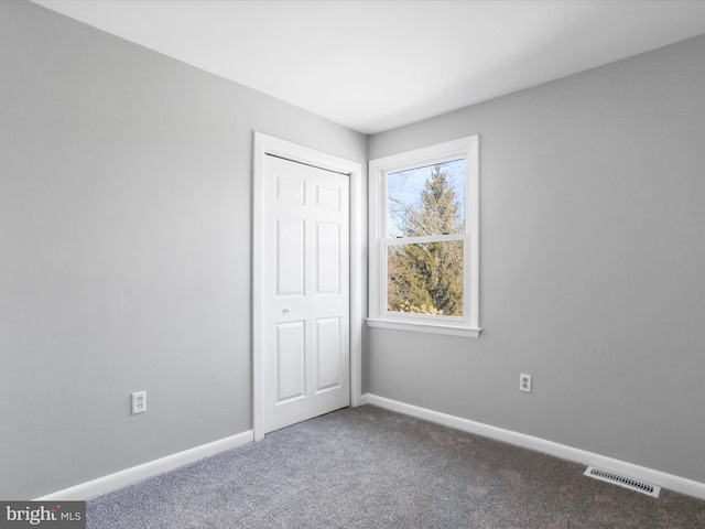 unfurnished bedroom featuring carpet and a closet