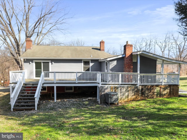 back of property with a yard, a deck, and central AC