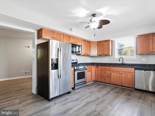 kitchen featuring ceiling fan, sink, stainless steel appliances, and wood-type flooring