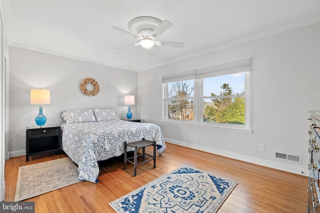 bedroom with visible vents, crown molding, and wood finished floors