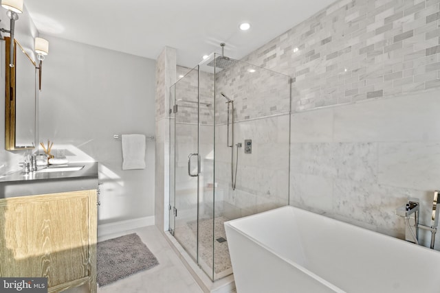 full bath with marble finish floor, double vanity, a stall shower, a sink, and a freestanding tub